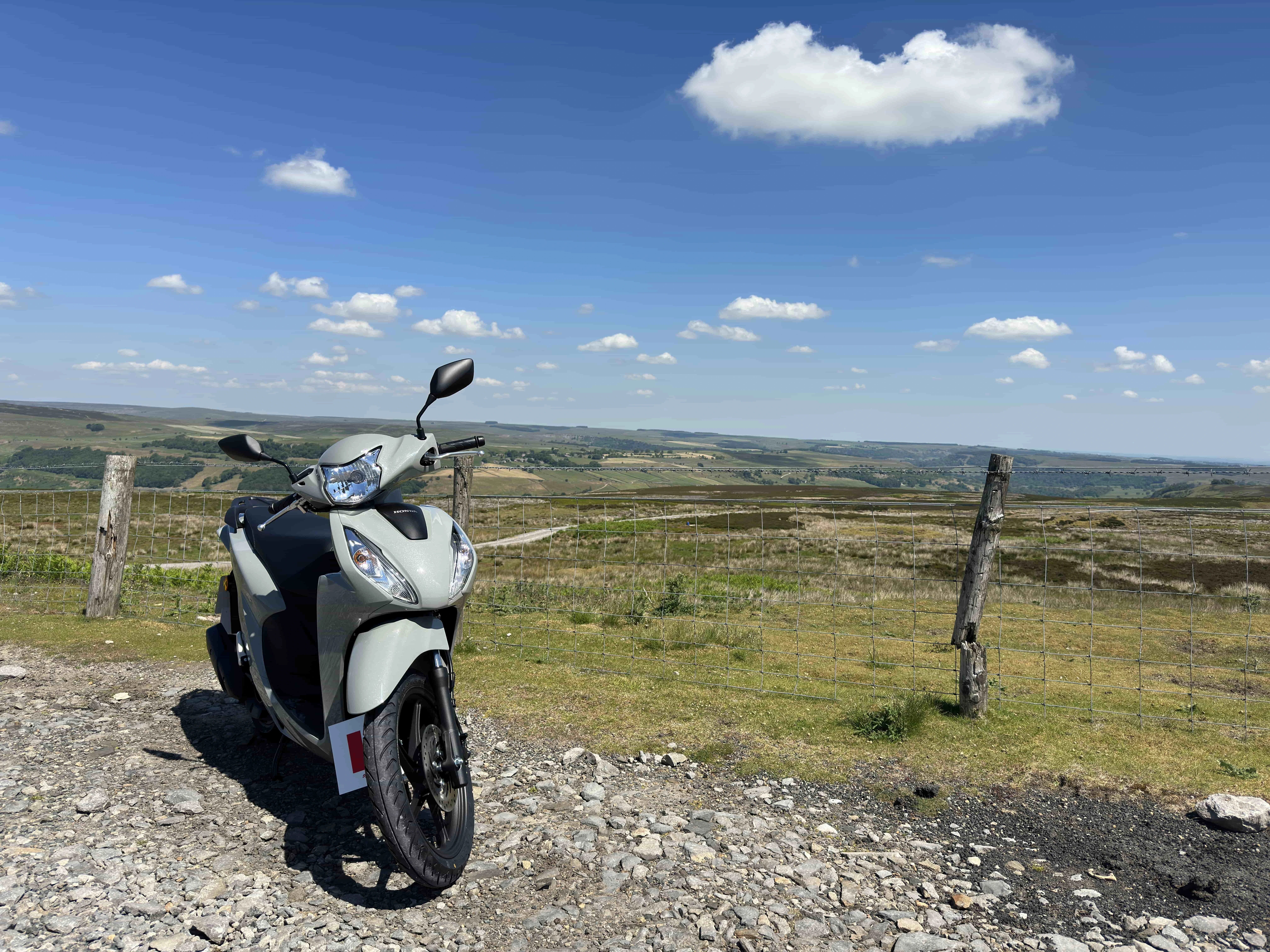 front of moped with a vast Dales scene in background